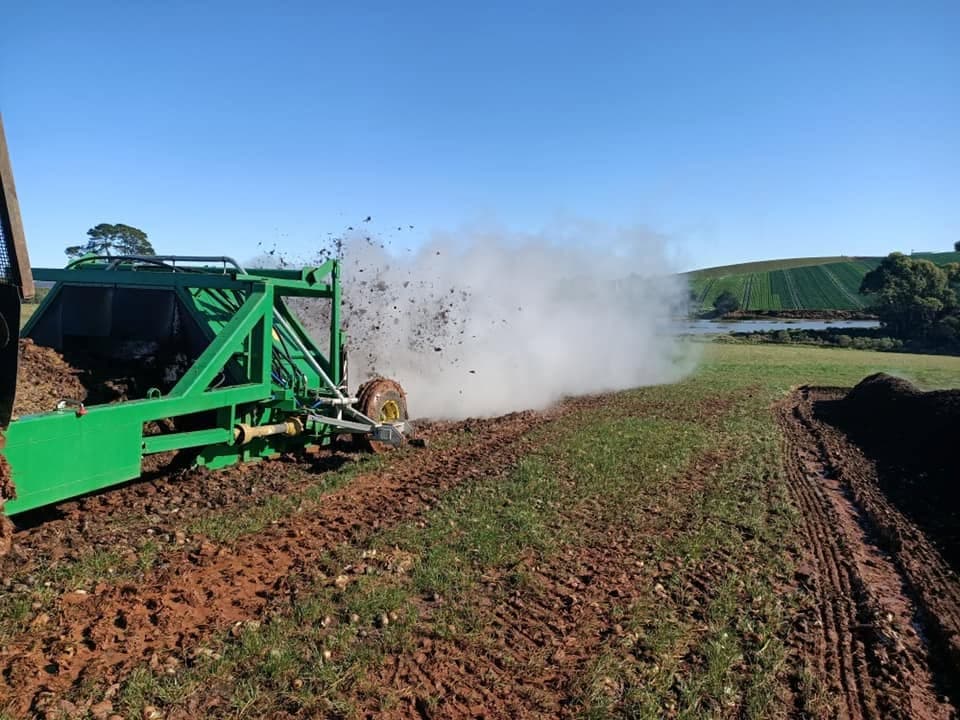 Compost turner aerating a windrow on site