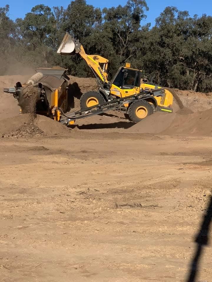 Loader feeding organic material into processing equipment